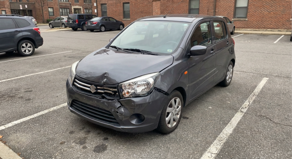 Voiture accidentée garée sur un parking avec pare-chocs endommagé